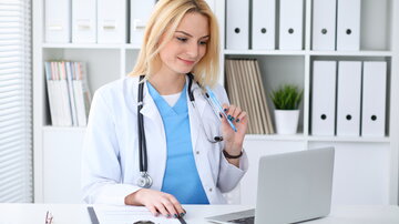 Eine Ärztin sitzt an einem Laptop